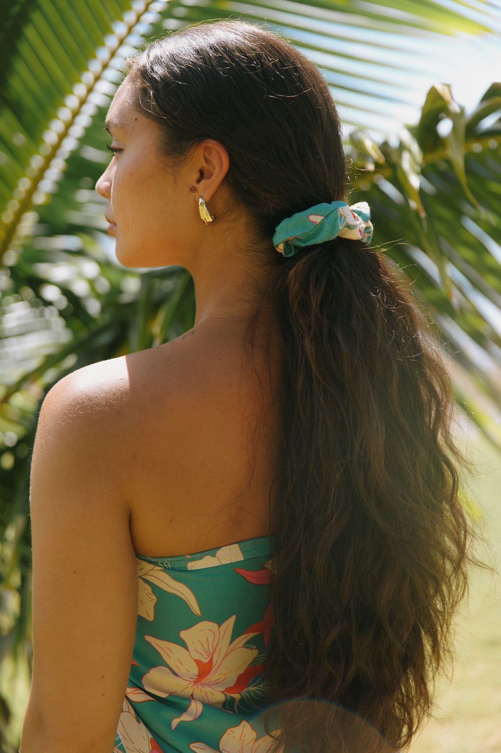 woman with brown hair wearing teal scrunchie with white ginger print