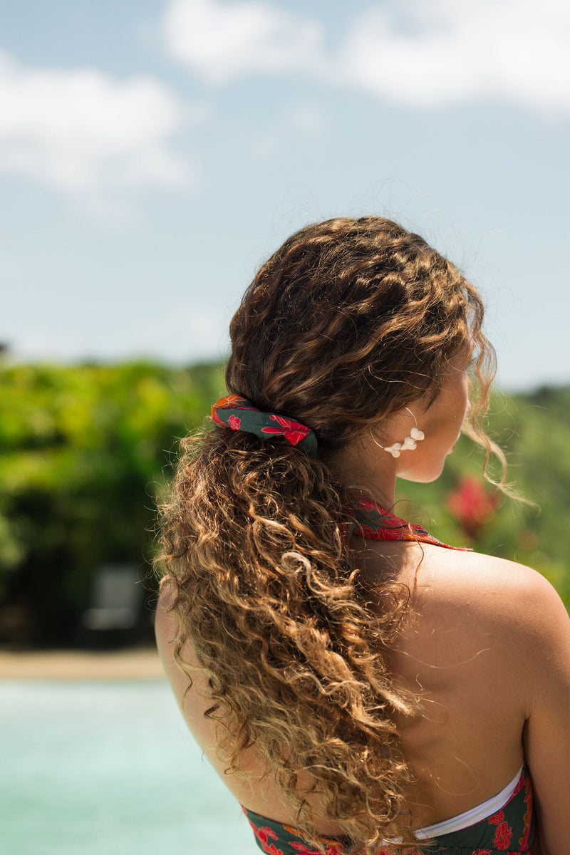 woman with brown hair wearing a colorful scrunchie with tropical lei print