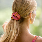 woman wearing pink scrunchie with lei day print