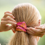 woman wearing pink scrunchie with lei day print
