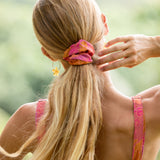 woman wearing pink scrunchie with lei day print