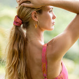 woman wearing pink scrunchie with lei day print