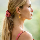 woman wearing pink scrunchie with lei day print