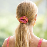 woman wearing pink scrunchie with lei day print