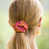 woman wearing pink scrunchie with lei day print