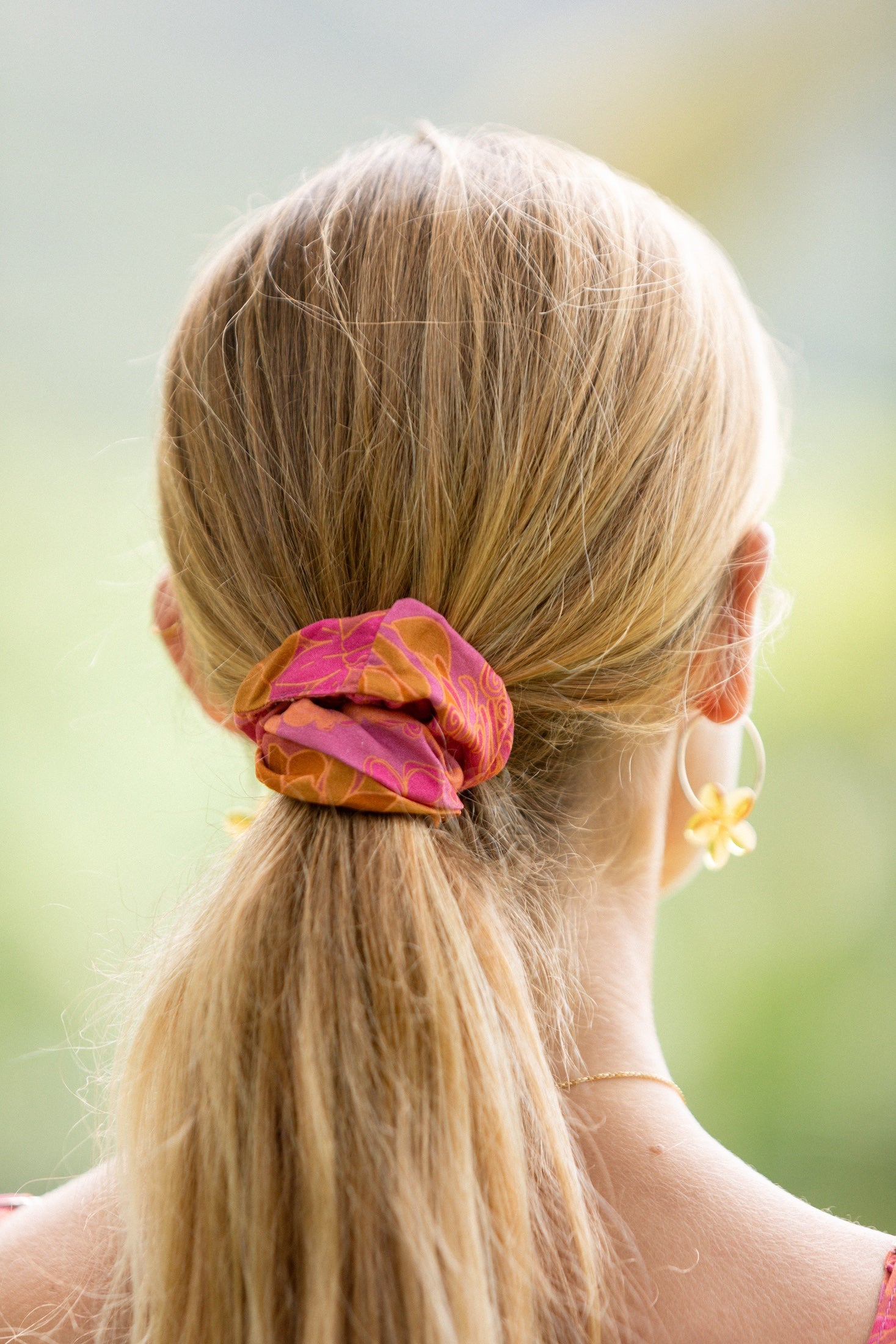 woman wearing pink scrunchie with lei day print