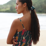 woman with brown hair wearing a scrunchie with lei and shell print