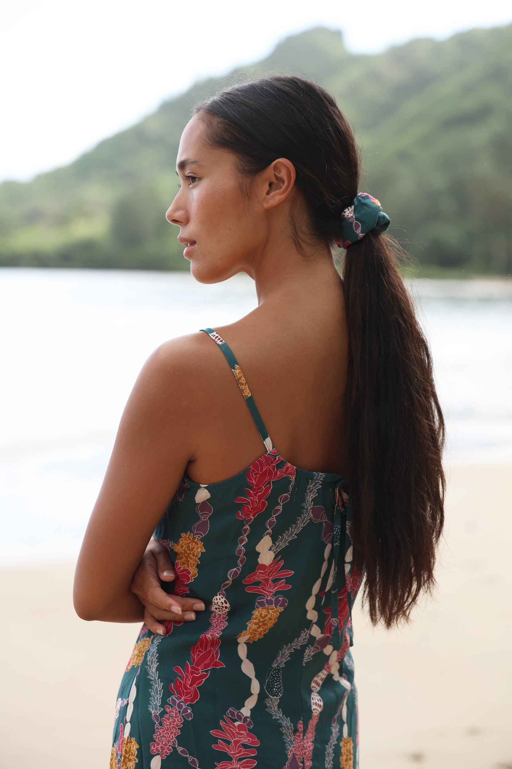 woman with brown hair wearing a scrunchie with lei and shell print