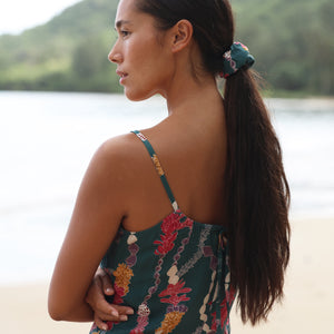 woman with brown hair wearing a scrunchie with lei and shell print