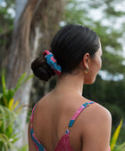 Woman wearing blue scrunchie with pink floral print.