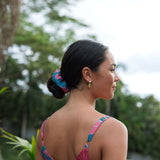 Woman wearing blue scrunchie with pink floral print.