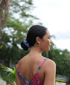 Woman wearing blue scrunchie with pink floral print.