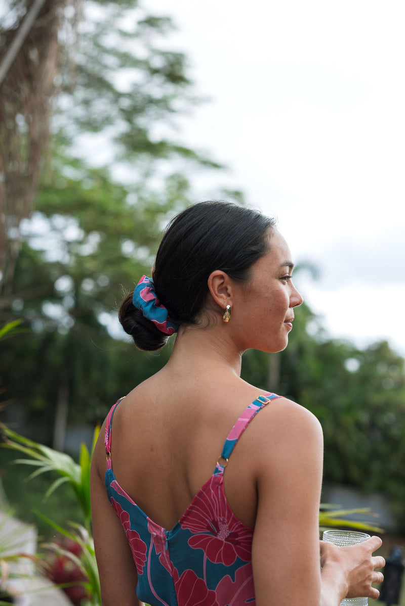 Woman wearing blue scrunchie with pink floral print.