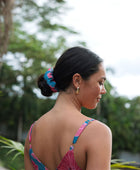 Woman wearing blue scrunchie with pink floral print.