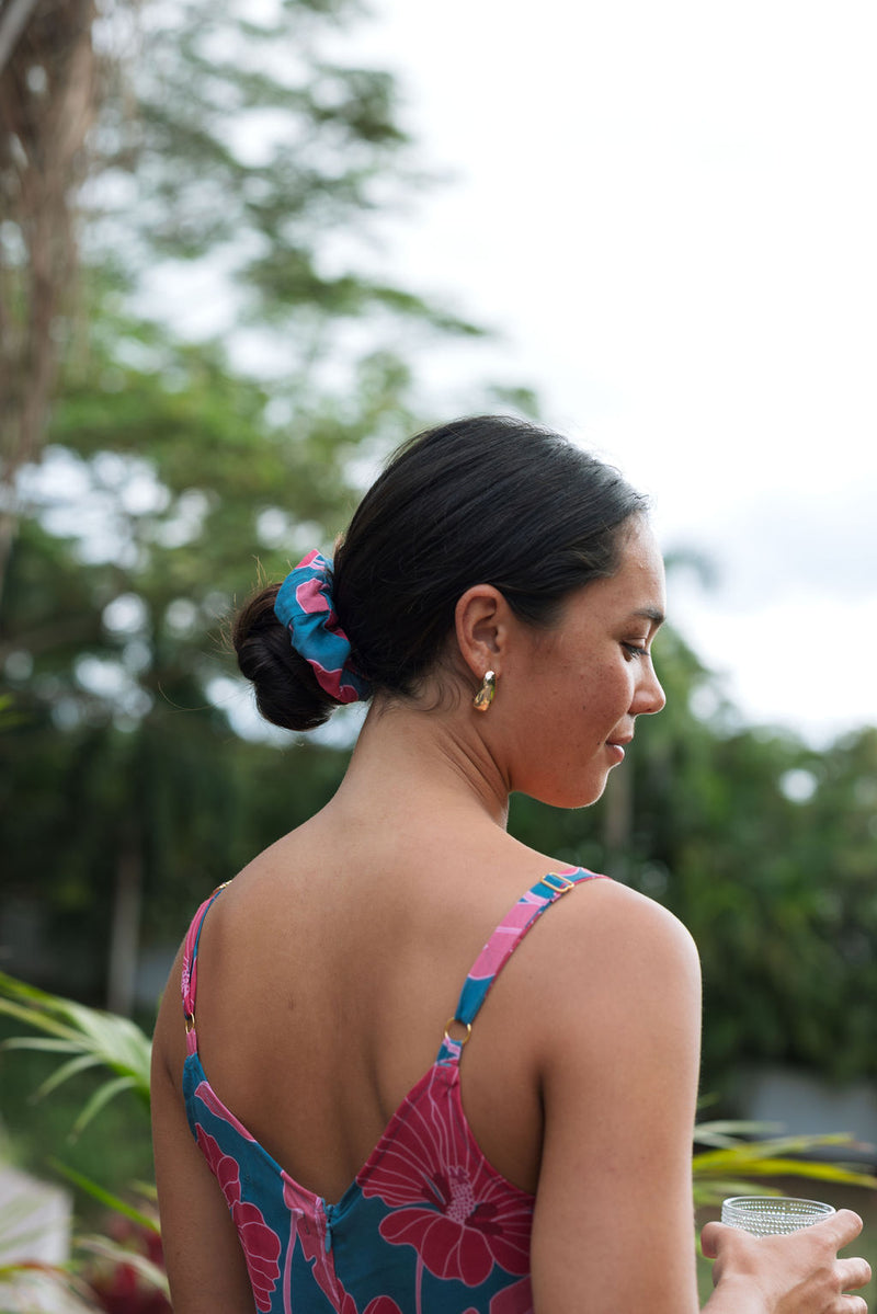 Woman wearing blue scrunchie with pink floral print.