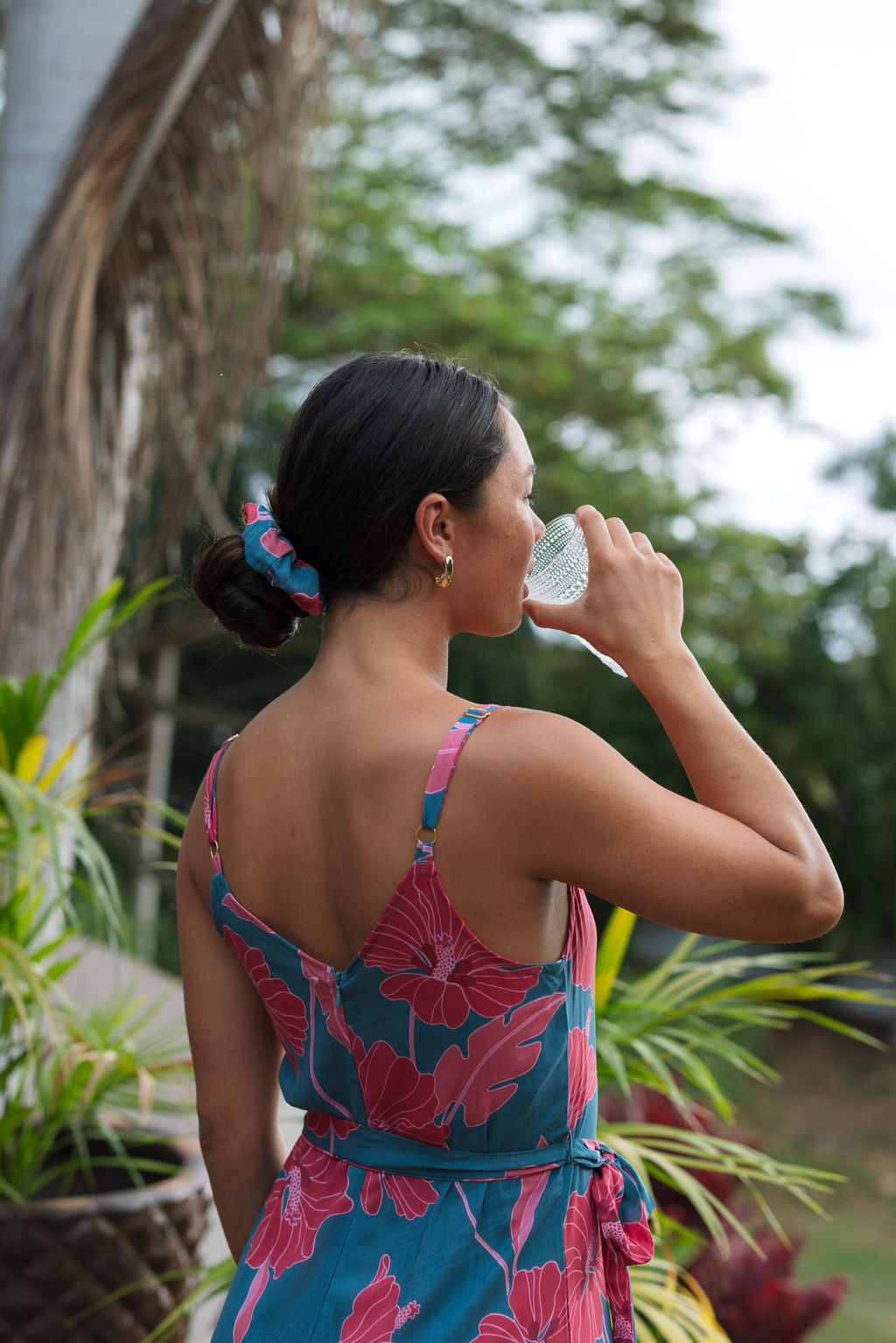 Woman wearing blue scrunchie with pink floral print.