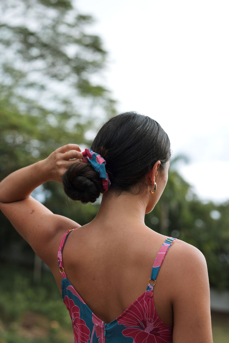 Woman wearing blue scrunchie with pink floral print.