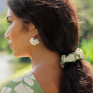 girl with brown hair wearing green scrunchie with native Hawaii plant pattern