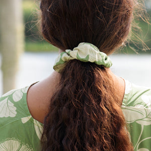 girl with brown hair wearing green scrunchie with native Hawaii plant pattern