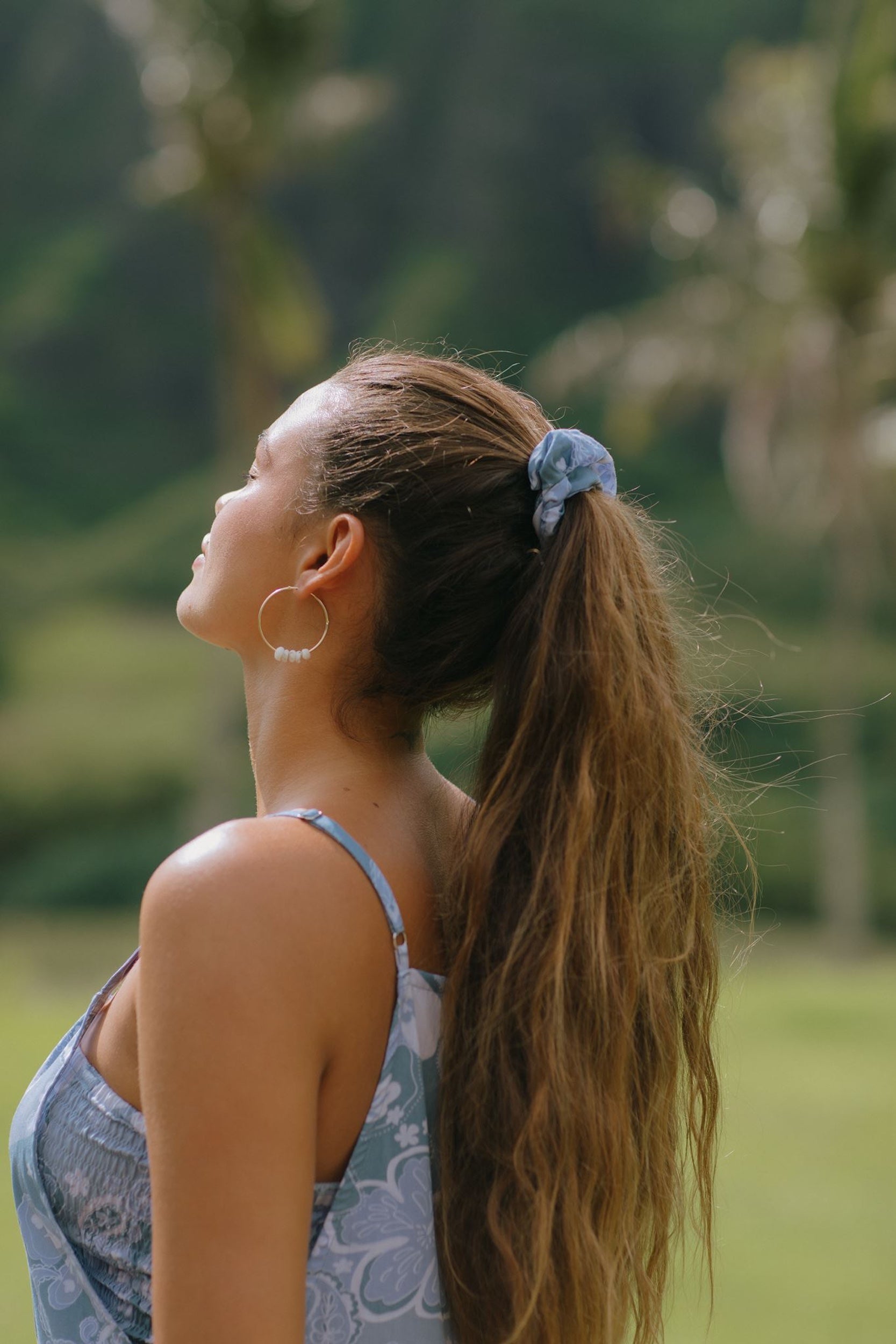 woman with brown hair wearing blue paisley print scrunchie 