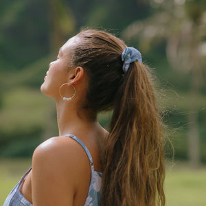 woman with brown hair wearing blue paisley print scrunchie 