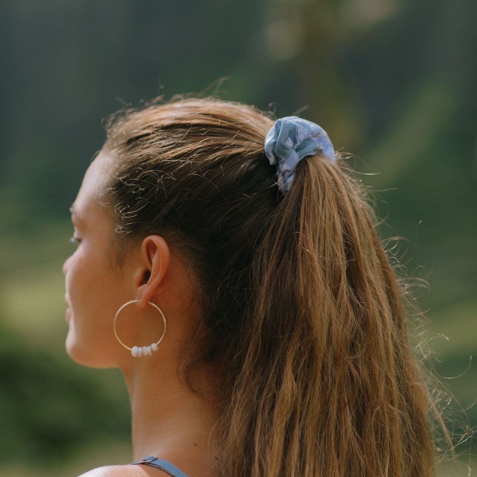 woman with brown hair wearing blue paisley print scrunchie 