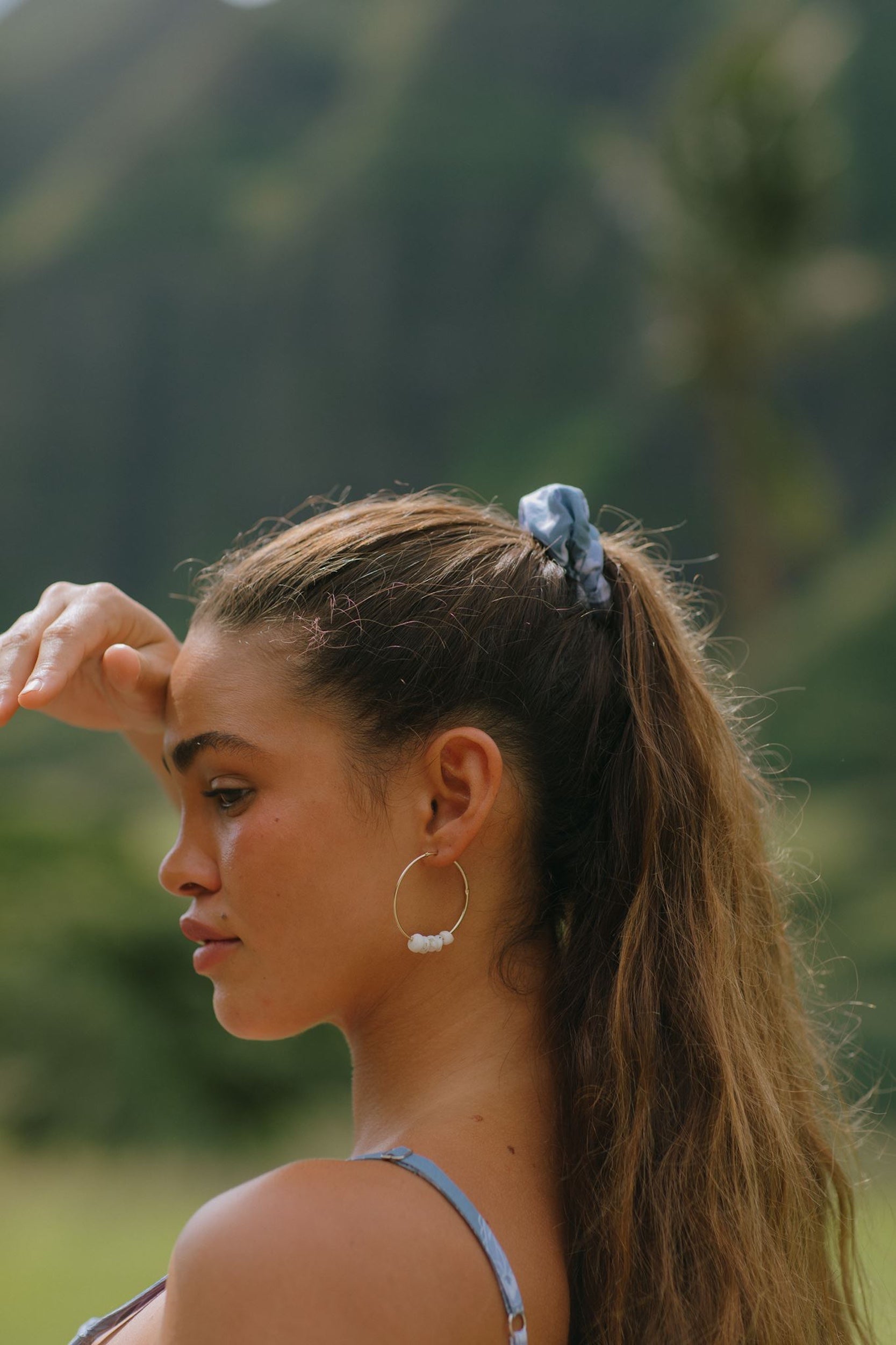 woman with brown hair wearing blue paisley print scrunchie 