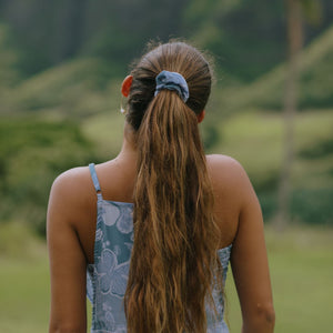 woman with brown hair wearing blue paisley print scrunchie 