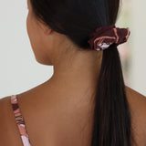woman wearing brown scrunchie with protea pattern