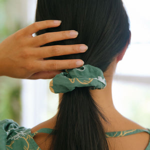 woman wearing lush green scrunchie with puakenikeni print