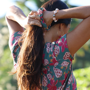 woman wearing a teal scrunchie with shell and pua print