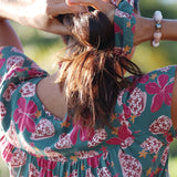 woman wearing a teal scrunchie with shell and pua print
