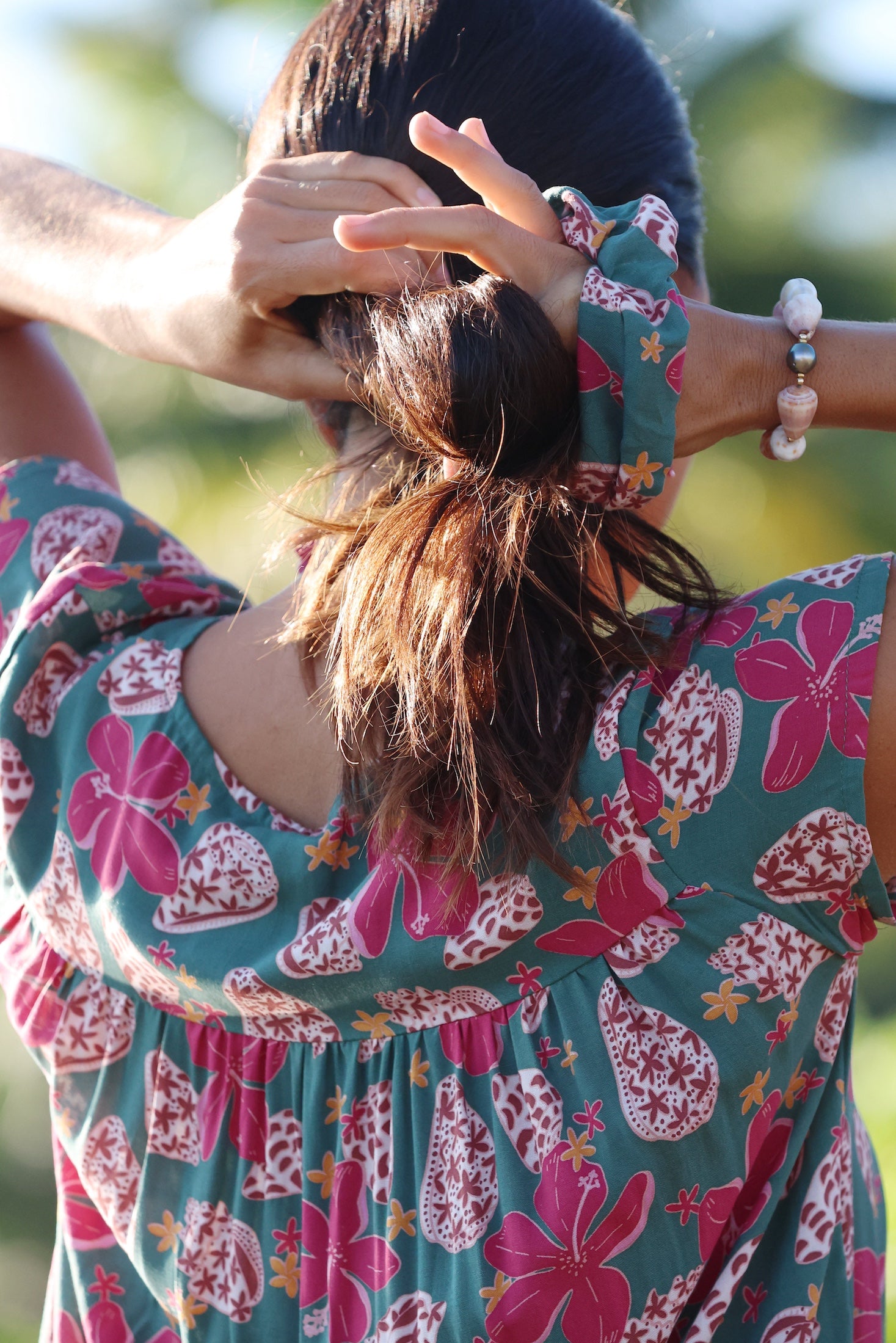 woman wearing a teal scrunchie with shell and pua print