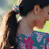 woman wearing a teal scrunchie with shell and pua print