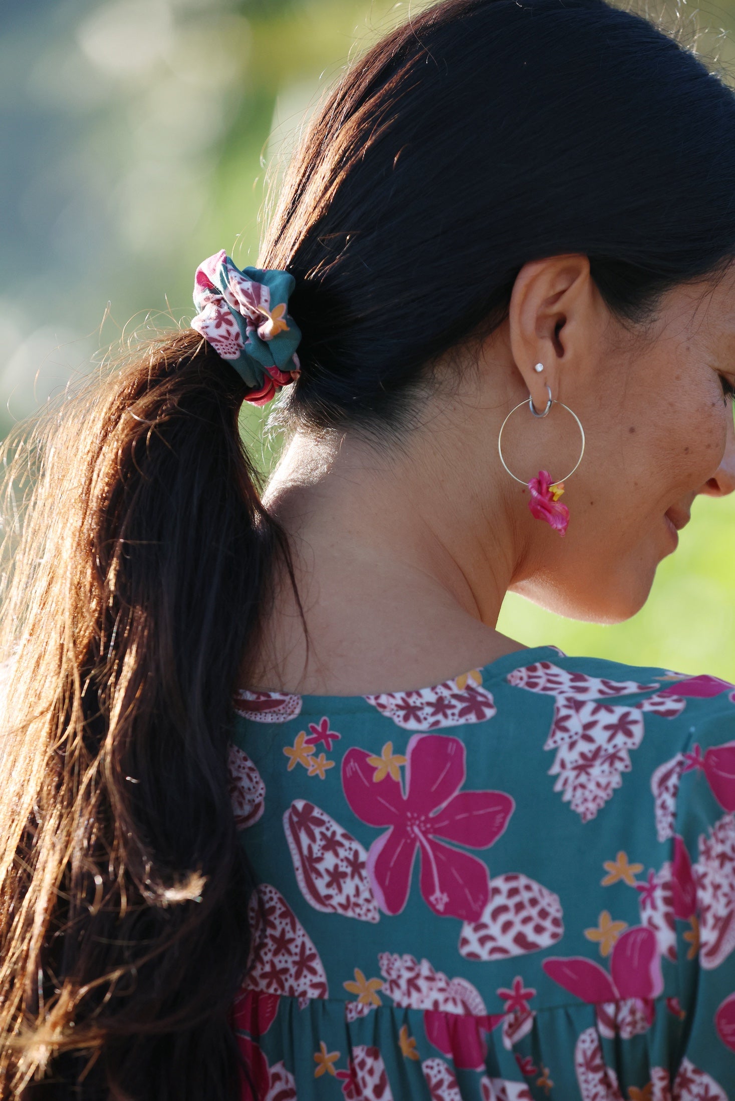 woman wearing a teal scrunchie with shell and pua print