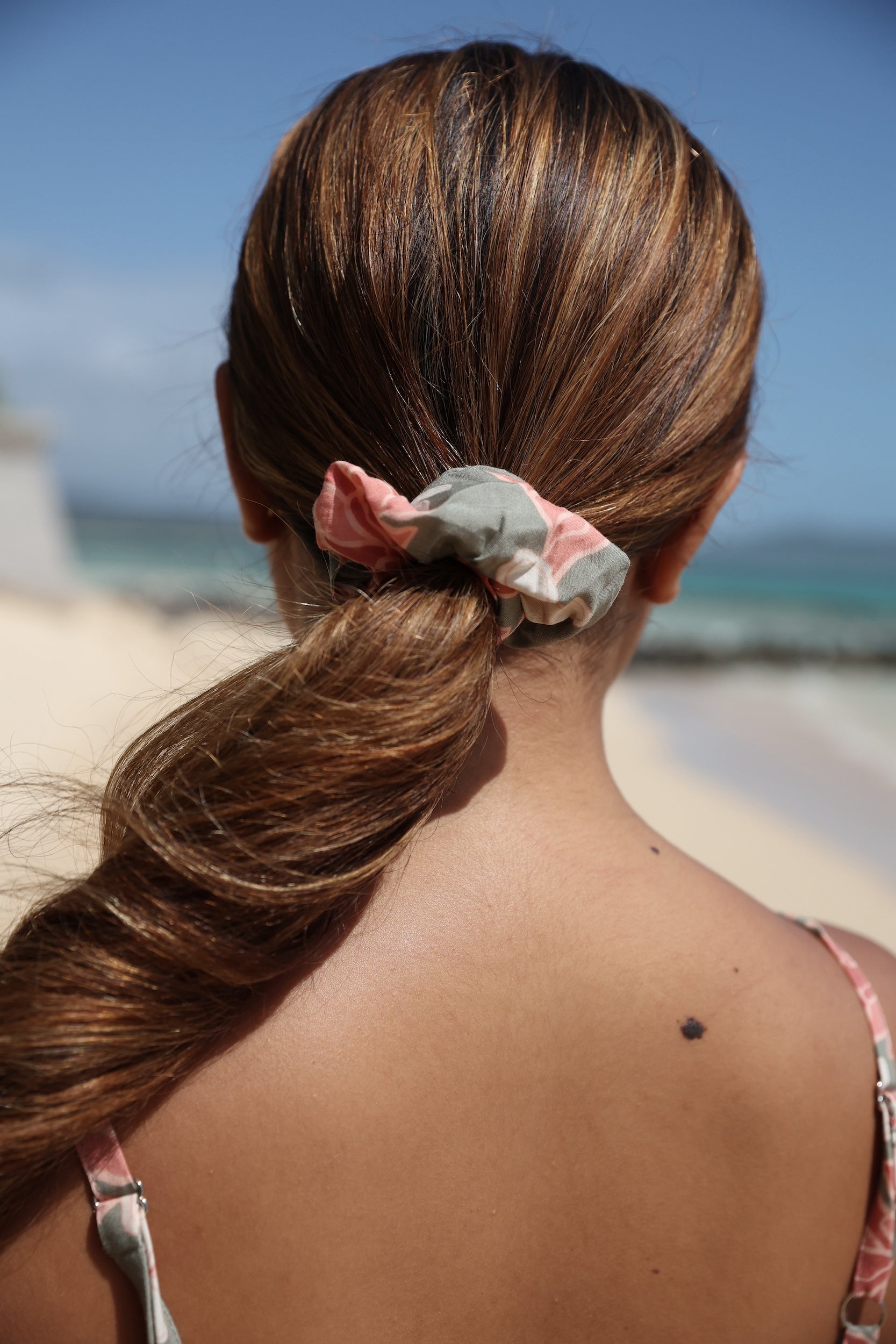 woman with brown hair wearing jade colored scrunchie with tiare ginger print