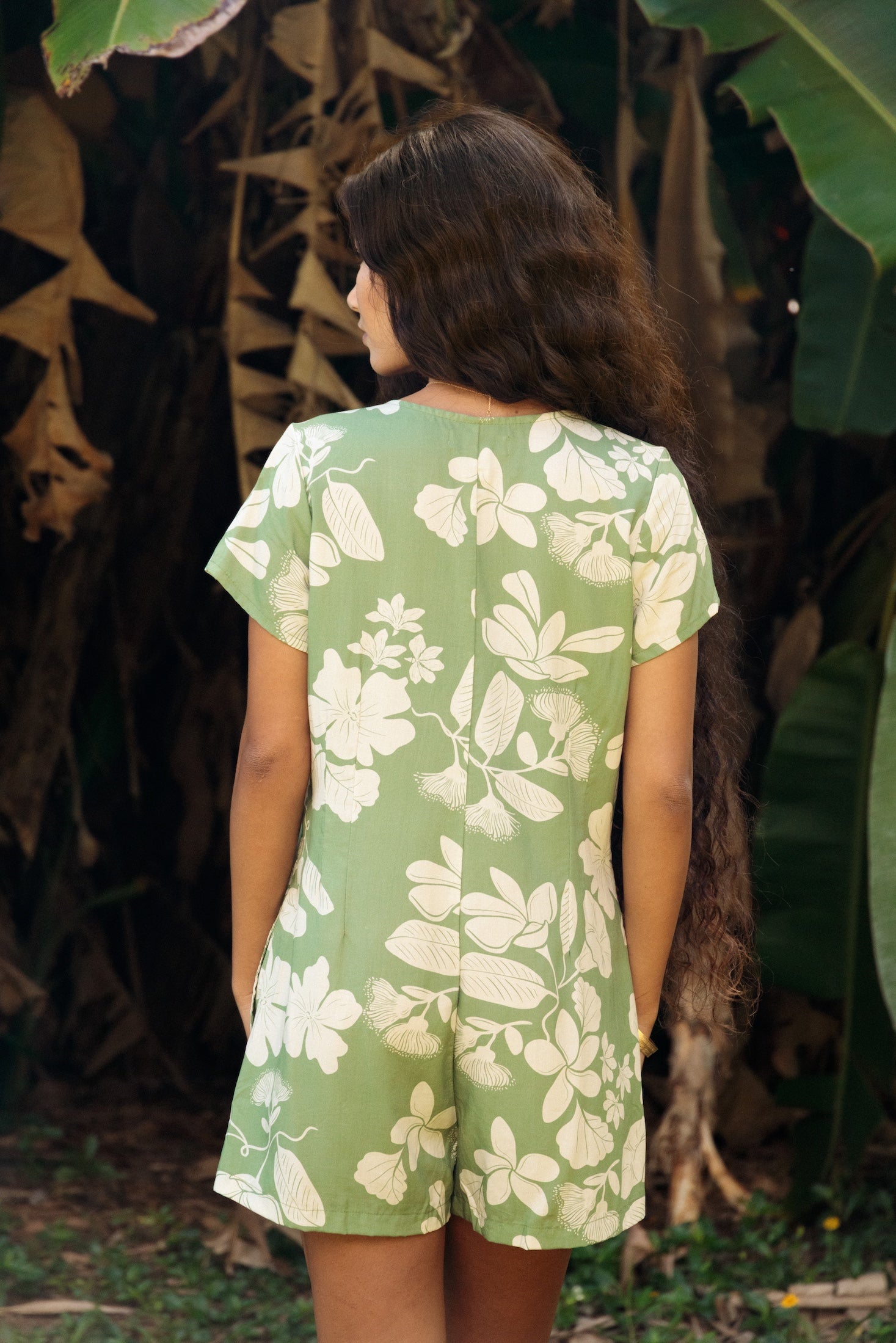 woman wearing green romper with native Hawaiian plants