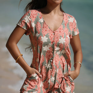woman with brown hair wearing a jade colored button up romper with tiare ginger print