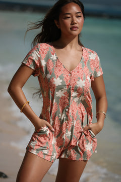 woman with brown hair wearing a jade colored button up romper with tiare ginger print