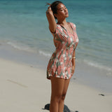 woman with brown hair wearing a jade colored button up romper with tiare ginger print