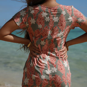 woman with brown hair wearing a jade colored button up romper with tiare ginger print