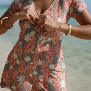 woman with brown hair wearing a jade colored button up romper with tiare ginger print