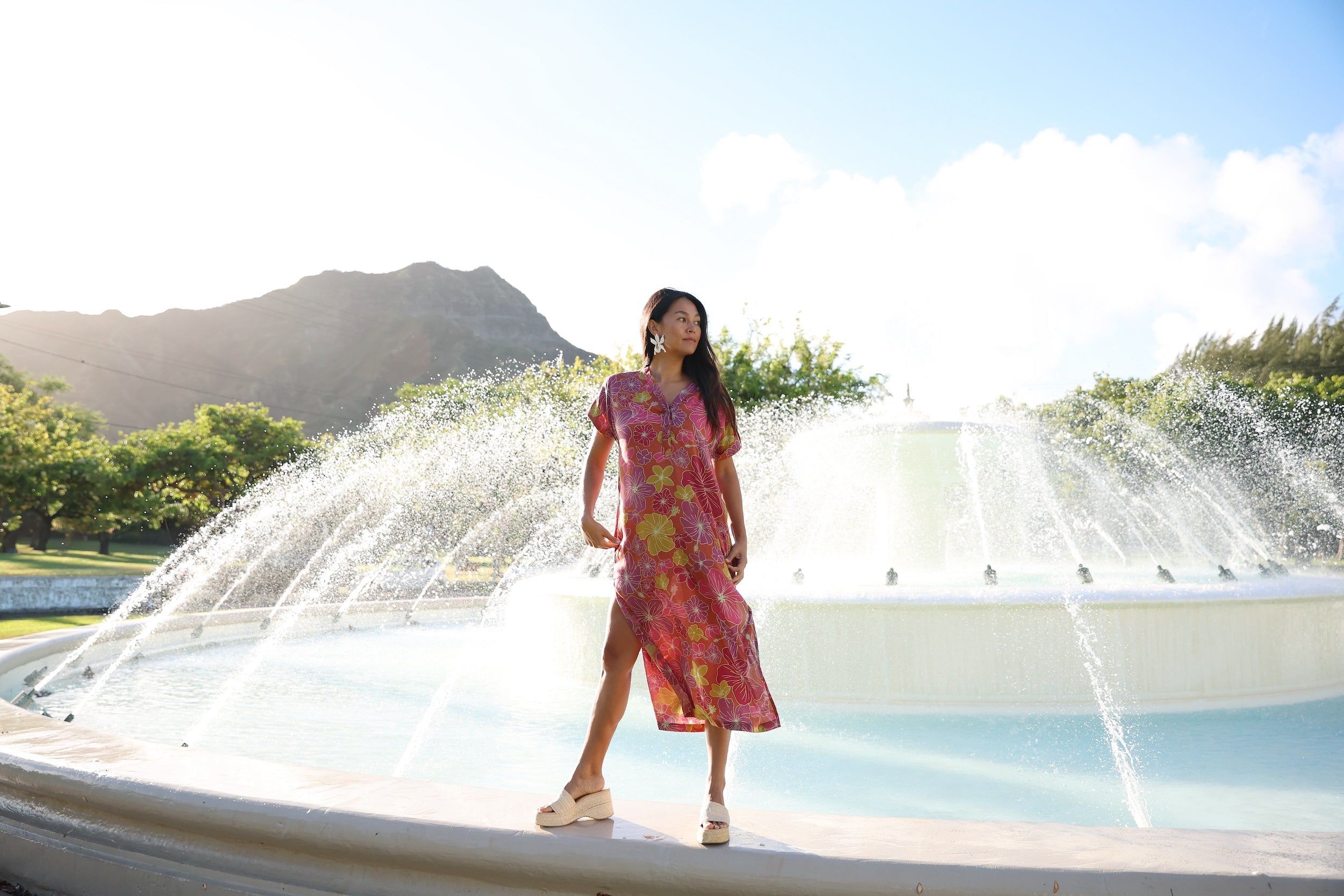 woman wearing terracotta colored v neck maxi dress with large purple and yellow flower print