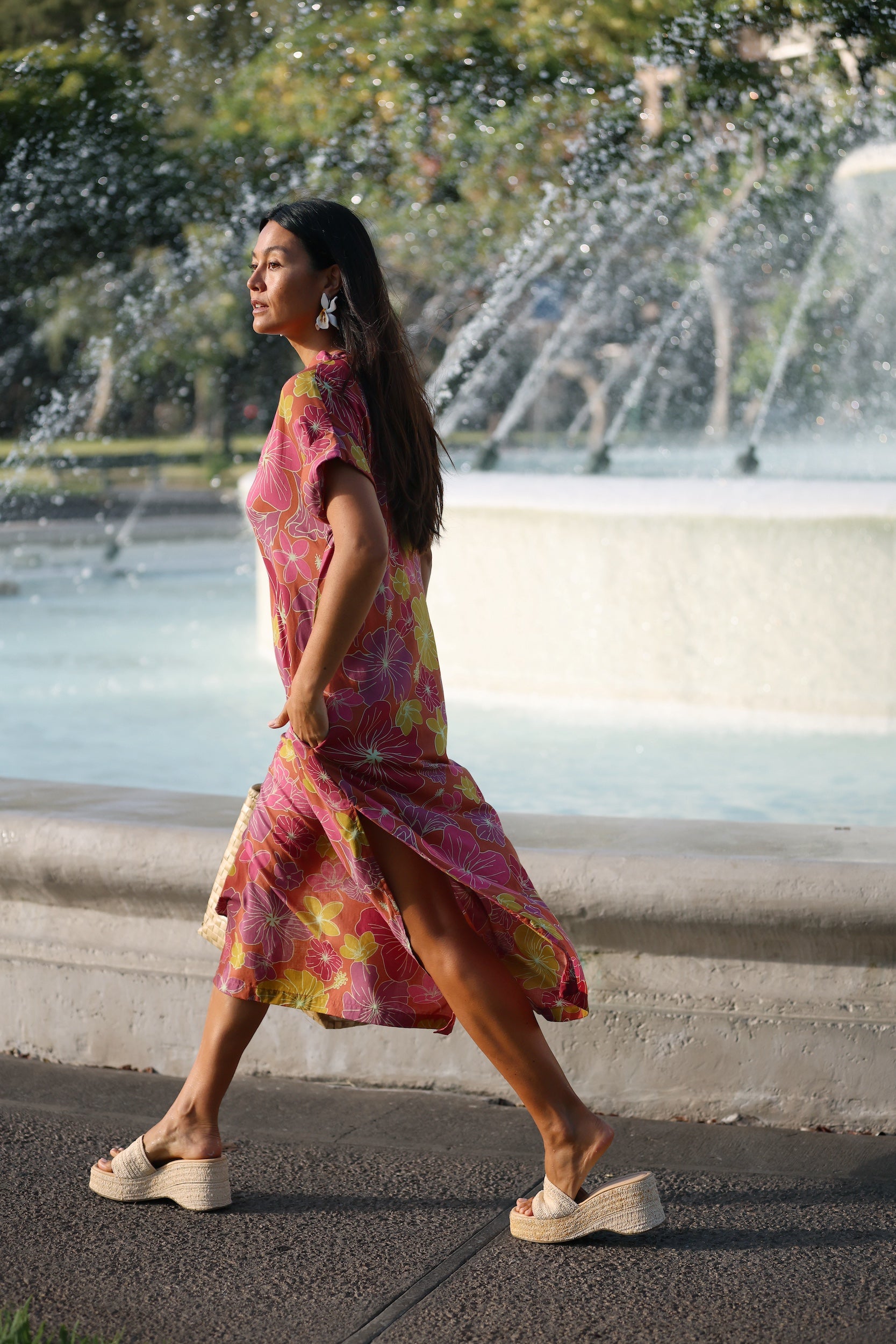 woman wearing terracotta colored v neck maxi dress with large purple and yellow flower print