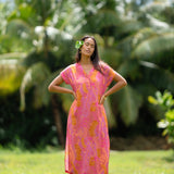 woman wearing a pink v neck maxi dress with lei print
