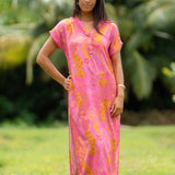 woman wearing a pink v neck maxi dress with lei print