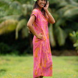 woman wearing a pink v neck maxi dress with lei print