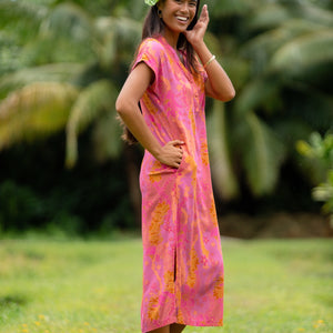 woman wearing a pink v neck maxi dress with lei print