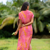 woman wearing a pink v neck maxi dress with lei print