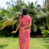 woman wearing a pink v neck maxi dress with lei print